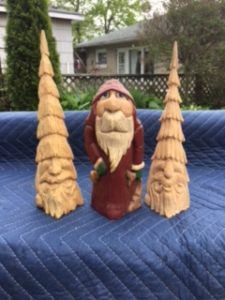 Wood carving of gnome with two trees