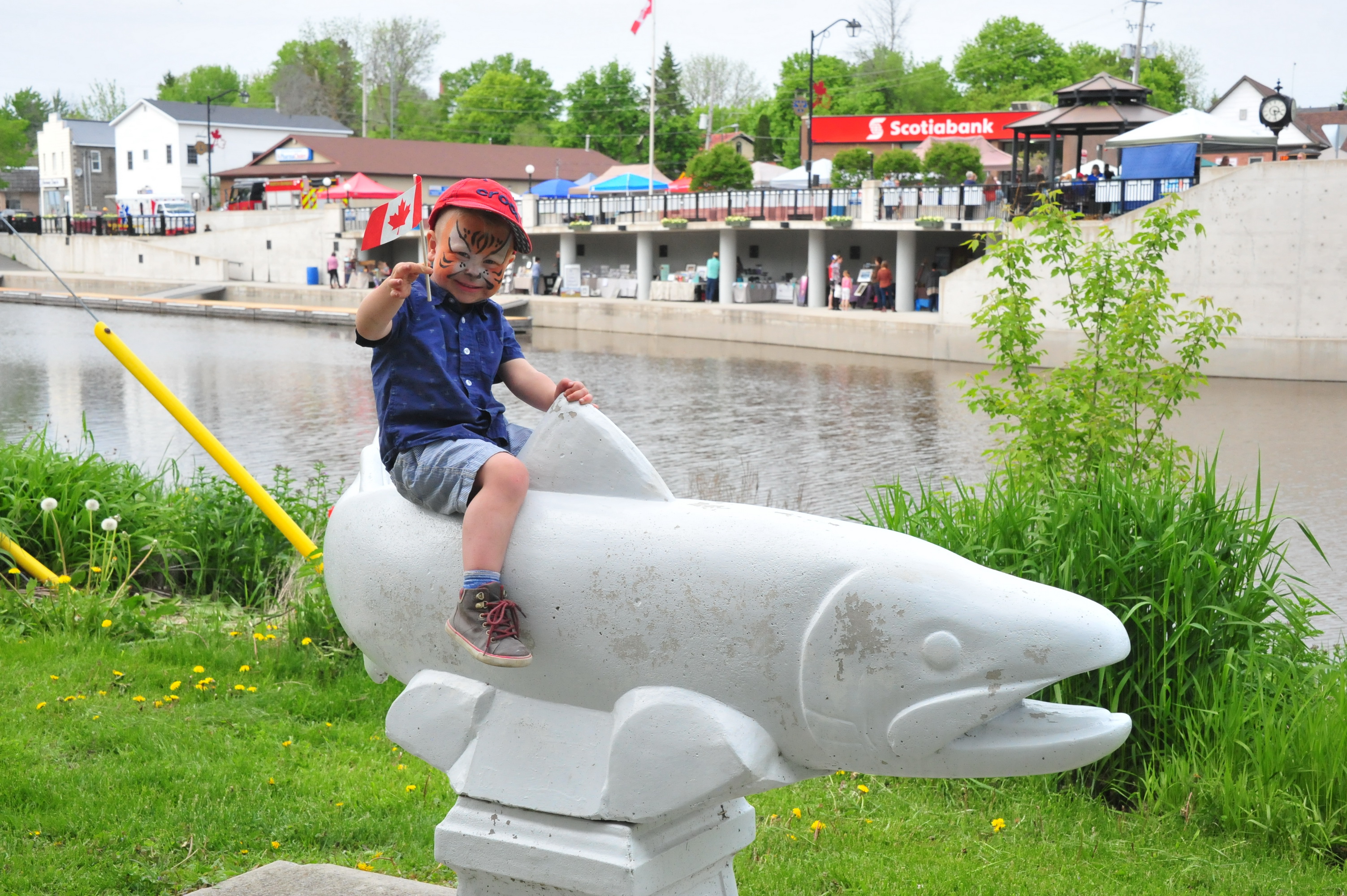 Boy on cement fish statue