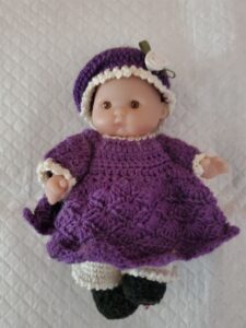 Doll in purple knitted outfit