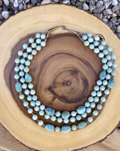 Blue beaded necklace on wood stump